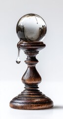 Clear glass orb on a dark wooden pedestal, dripping liquid