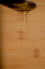 Honey dripping from a spoon on a wooden background