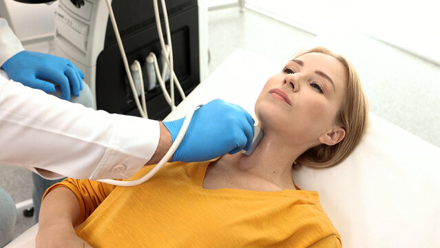 Woman patient receives thyroid diagnostics. Treatment of thyrotoxicosis, and hypothyroidism. Ultrasound diagnostics of endocrine system and thyroid