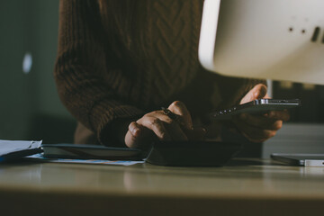 Close-up of businessman's hands making notes, mobiles, chart, desk, office