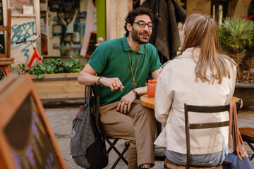 A man smiles and talks to a woman while they sit at a table