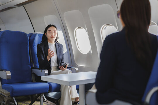 Businesswomen having a conversation on a private jet flight - Powered by Adobe