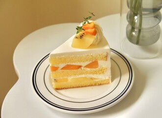 A delectable slice of cake with rich layers of cream and frosting, topped with fresh fruit or sprinkles. Perfect for dessert photography, showcasing indulgence and sweetness in food-related projects.