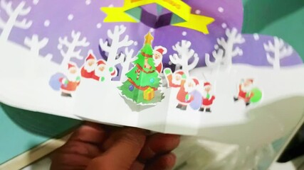Unveiling a heartfelt Christmas greeting. 3D pop-up card display with festive Santa and winter.