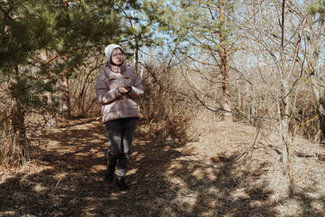 Fototapeta premium A young woman in a park uses her phone to navigate, enjoying nature while finding her way. Captures modern exploration, relaxation, and technology in daily life