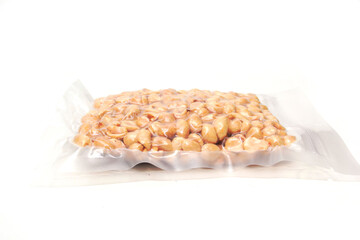 roasted peanuts in vacuum-sealed plastic packaging isolated on white background, good for food article or recipe