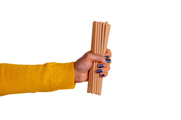 Close-up of a hand in a yellow sleeve holding reusable bamboo straws against transparent background, promoting sustainability and eco-conscious lifestyle.