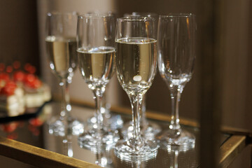 Golden bubbles rise in slender glasses, illuminating a moment of toast and cheer under the soft, ambient light