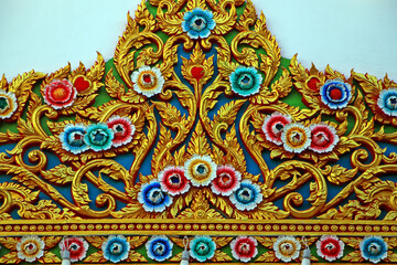 Traditional thai art showing colorful flowers and golden details decorating a temple
