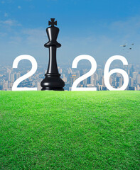 2026 white letter with black chess king on green grass field over modern city tower and skyscraper, Happy new year 2026 strategy and success concept