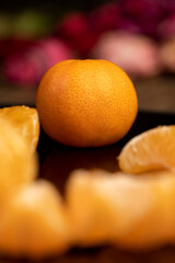 the reflection of an orange tangerine in a mirror surface close up, a peeled and juicy tangerine on a black mirror, closeup