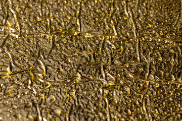 the wet golden crumpled surface used for packaging goods and food, the details of the golden foil covered with drops of water for packaging and long-term storage of food