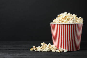 Classic red and white striped box filled with delicious, fluffy popcorn, 3D glasses on a black background.

