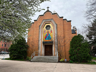 Brick St. Nicholas Ukrainian Catholic Church  with mosaic icon above the door in a USA neighborhood setting