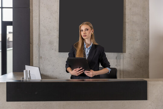 Young businesswoman standing at a reception desk