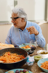 A man sits at a table and talks while looking away