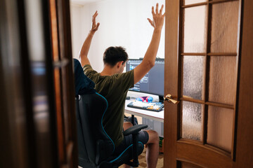 Stressed programmer slumping in gaming chair, head buried in hands, experiencing frustration after...
