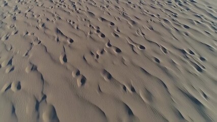 High-angle view of rippled desert sand. Detailed texture of wind-swept dunes with subtle depressions - Powered by Adobe