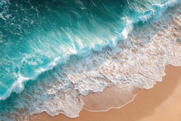 Aerial view of turquoise ocean waves crashing onto a sandy beach with white foam