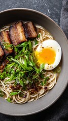 Japanese ramen noodle soup with soft boiled egg, sliced pork and green onions in dark bowl