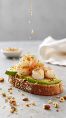 Gourmet toast with avocado, shrimp and chopped nuts, drizzled with golden olive oil in minimal style