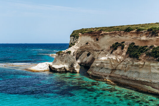 Scenic Munxar Window limestone rock arch rising above the turquoise Mediterranean Sea, Marsaskala, Malta