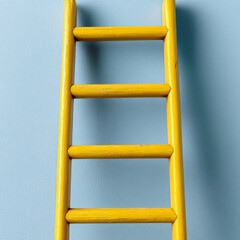 Yellow ladder against a plain blue background.