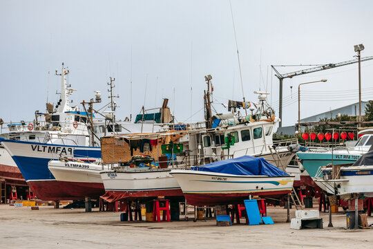Marsaxlokk, Malta - April 13, 2025: Fishing boats on dry dock undergoing maintenance, including the bright blue vessel Roberta Valletta, at the shipyard in the traditional Maltese fishing village of M