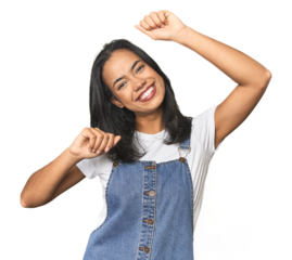 Simple portrait of a young Latina celebrating a special day, jumps and raise arms with energy.
