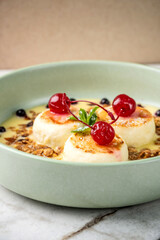 Delicious homemade syrniki with creamy sauce and cherries.