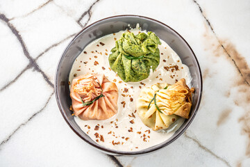 A top view of assorted savory crepes in a creamy sauce.