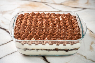 Classic homemade tiramisu in a glass dish.