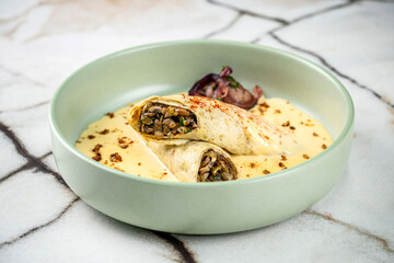 Savory crepes filled with mushrooms served in a creamy sauce.