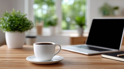 Modern Workspace Featuring Laptop Coffee and Plant on Wooden Desk in Bright Room with Natural Light Near Window