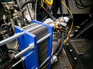 Machinery showing hydraulic components in a technical workshop setting with focus on a heat exchanger