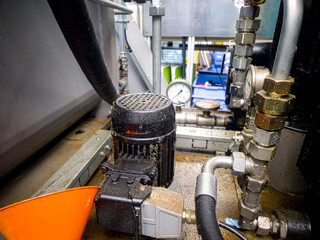 Equipment in a mechanical workshop with focus on pump and pressure gauge during daytime
