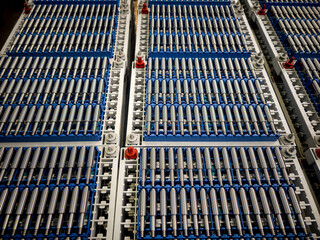 Industrial machinery showcasing rows of blue and silver hydraulic cylinders in a factory setting