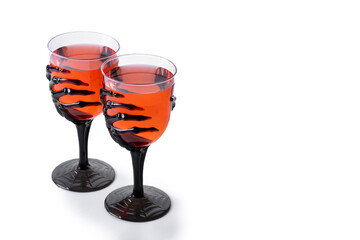 Halloween spooky red cocktail in skeleton hand glass isolated on white background. Copy space