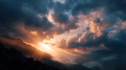 Dramatic sunbeams pierce dark clouds over a majestic mountain range during sunrise or sunset casting a golden glow