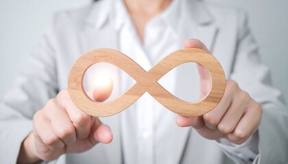 Wooden infinity symbol touched by professional woman’s hand