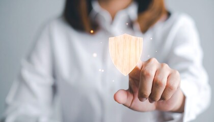 Businesswoman hand touching wooden shield icon for security and protection concept