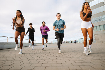 A group of five athletes run next to each other