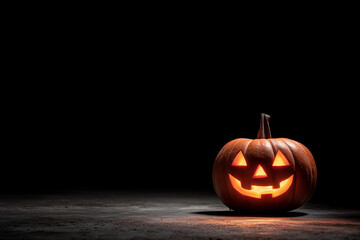 Spooky jack-o’-lantern glowing at corner, wide empty black space for copy