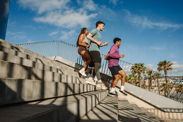 A group of five athletes are running down the stairs