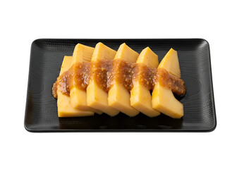 Slices of bamboo shoots, glistening with a savory sauce, are artfully arranged on a dark plate.
