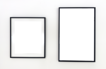 Two empty black photo frames of different sizes hanging on a white wall. Minimalist mockup for