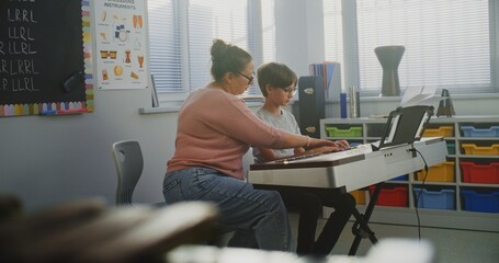 Talented Boy Playing Piano During Music Lesson in Elementary School, Rehearsing Before Musical Performance. Teacher Supporting and Teaching Future Pianist. Musical Education, Piano Practice Class.
