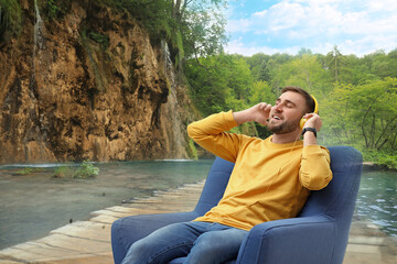 Happy man listening to sounds of nature which making him feel calm. Double exposure of with beautiful landscape