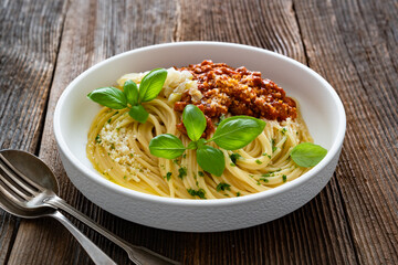 Spaghetti con ragù alla bolognese - pasta with minced meat and tomato sauce on wooden table	