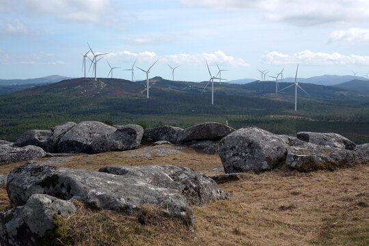 Parco eolico su colline rocciose, turbine a vento che generano energia pulita in un paesaggio naturale Miradoiro das Tres R&iacute;as
